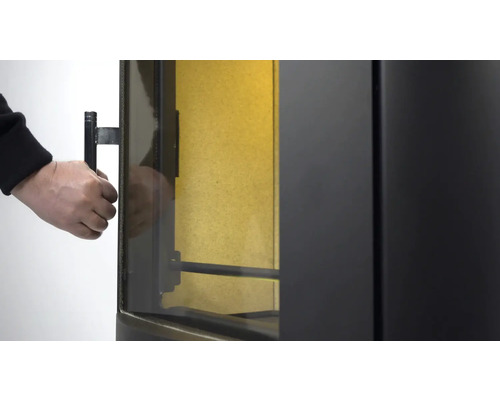 Detailopname van een houtkachel waarbij de deur wordt geopend