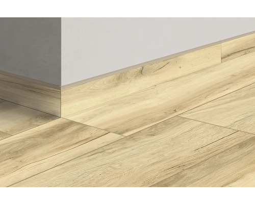 Aanzicht van laminaatvloer met bijpassende plint op een muur