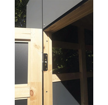 Detailopname van een houten deur met een metalen scharnier aan een tuinhuis