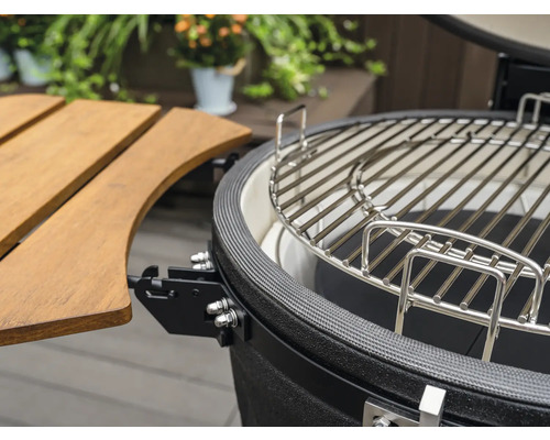 Detailopname van een keramische barbecue met grillrooster en bijzettafel
