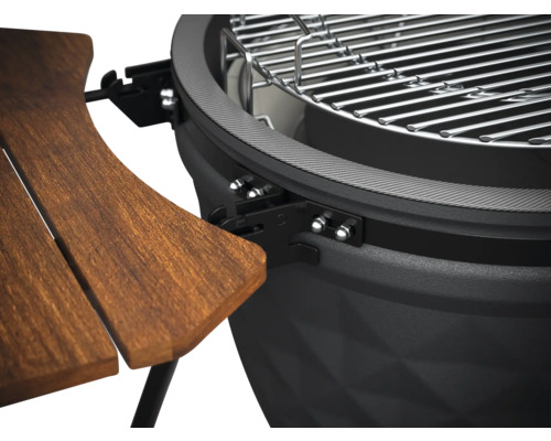 Detailweergave van een kogelbarbecue met houten tafel