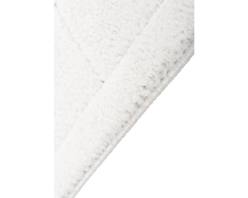 Detailopname van een wit vloerkleed met hoogpolig oppervlak