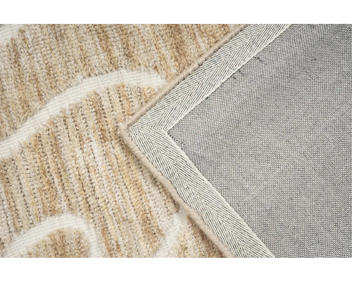 Detailweergave van een beige tapijt met patroon en textiele onderkant.