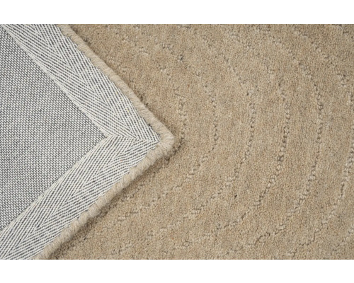 Detail van een beige tapijt met geweven rug