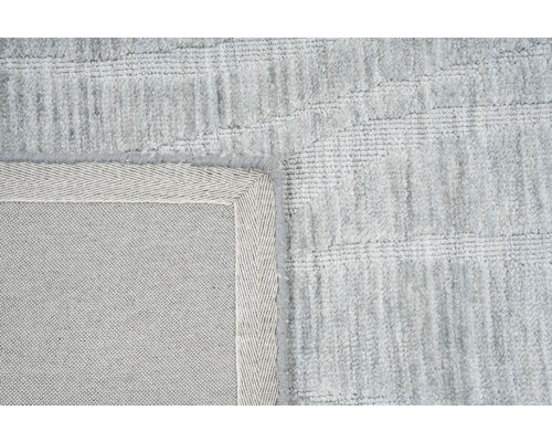 Detail van een lichtgekleurd tapijt met rand