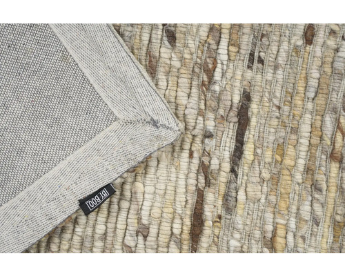 Detail van een vloerkleed met textuur en BY-BOO label