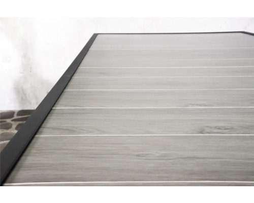 Detail van een tafelblad met houtlook en donker frame