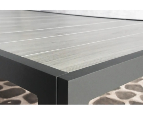 Detailopname van een tafel met grijze houtimitatie en antracietkleurig metalen frame