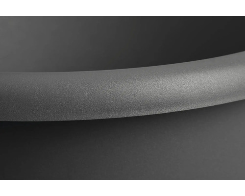 Detailopname van een ronde, zwarte plantenbak.