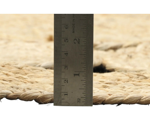 Close-up van een vloerkleed met een liniaal om de dikte te meten