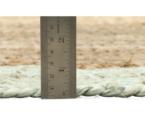 Detailopname van een vloerkleed met een meetlint om de hoogte te meten