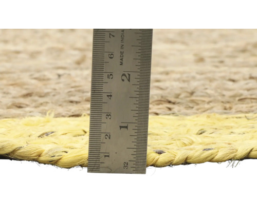 Close-up van een jute vloerkleed met een meetlat om de dikte te meten