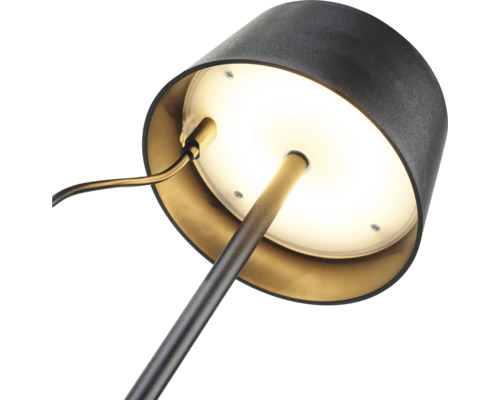 Close-up van een bureaulamp met ronde voet en lampenkap.