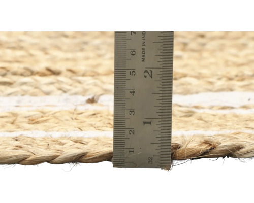 Close-up van een jute vloerkleed met een meetlint om de dikte te meten