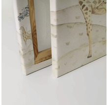 Close-up van twee canvas schilderijen met giraffemotieven en houten frame