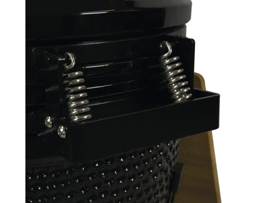 Detailopname van een keramische barbecue met veermechanisme en ventilatieschuif.