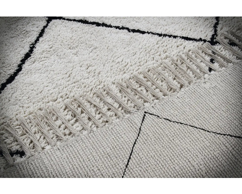 Detailweergave van een tapijt met geometrisch patroon en franjes