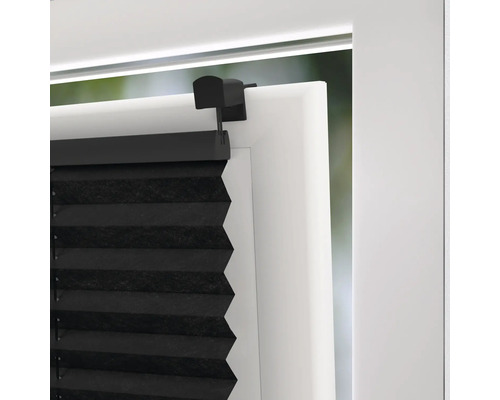 Gedetailleerd zicht op een zwart plisségordijn op een raam