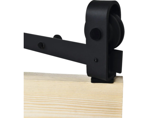 Detail van een zwarte schuifdeurbevestiging op een houten plank.