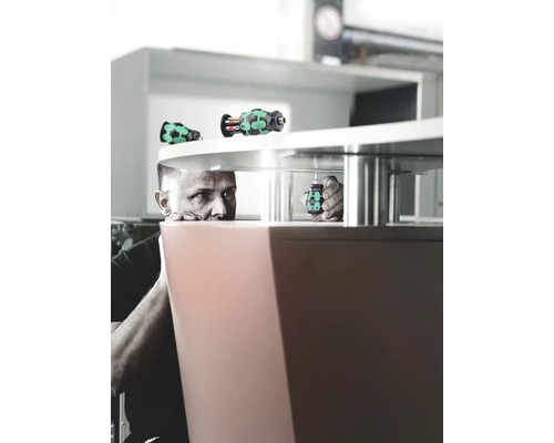 Een man bevestigt een meubelstuk met een schroevendraaier.