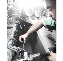 Een man die een machine repareert met een schroevendraaier.