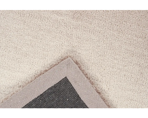 Detail van een beige vloerkleed met franjes