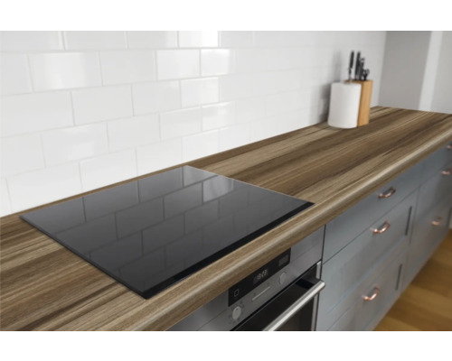 Keukenscène met houten aanrechtblad, kookplaat, wasbak en keukengerei