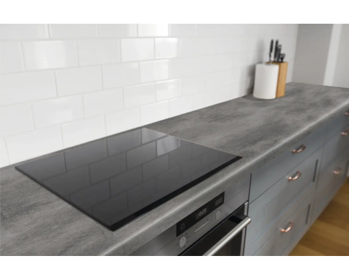 Keukenscène met kookplaat, werkblad, gootsteen en keukenkasten.