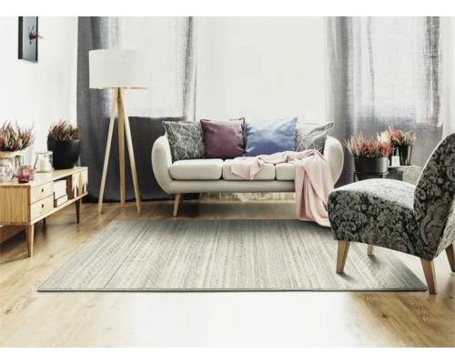 Woonkamer met vloerkleed, bank, fauteuil, vloerlamp en dressoir