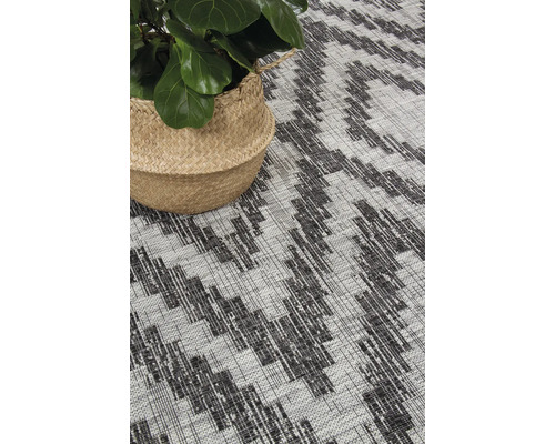 Vloerkleed met geometrisch patroon en plant in mand