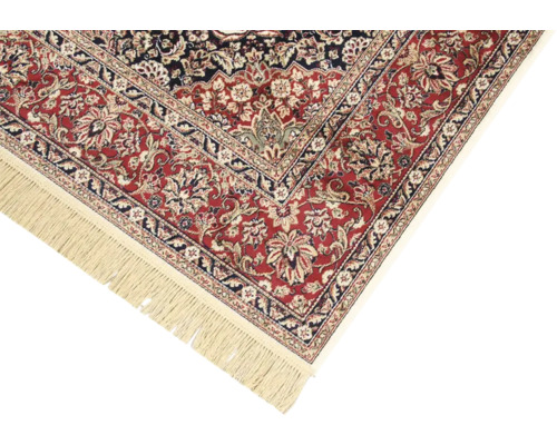 Detail van een rood tapijt met bloemmotief en franjes