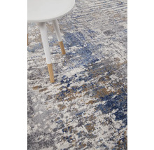 Vloerkleed met abstract patroon en een bijzettafel met houten poten