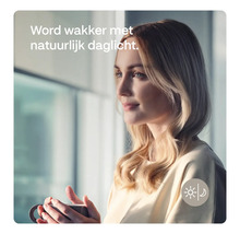 Vrouw houdt beker vast met de tekst: Word wakker met natuurlijk daglicht.