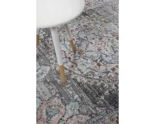 Detailweergave van een gemêleerd tapijt met een klein tafeltje