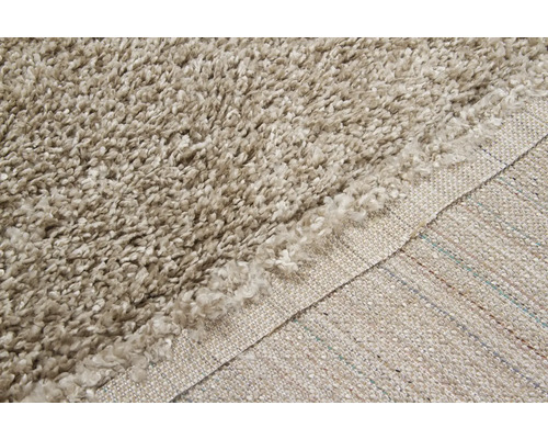 Gedetailleerde weergave van een beige hoogpolig shaggy tapijt