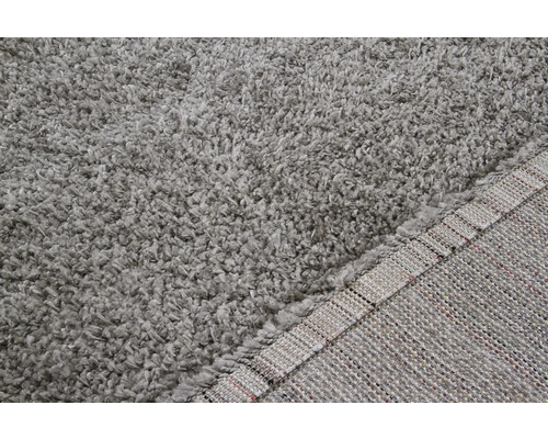 Gedetailleerde weergave van een grijs shaggy vloerkleed met een hoge poolhoogte