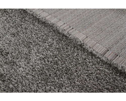 Gedetailleerde weergave van een grijs shaggy tapijt met een hoge pool.