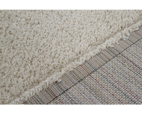 Detailopname van een beige shaggy tapijt met lange pool