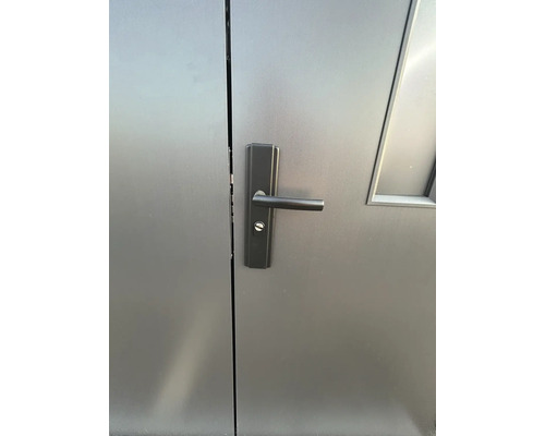 Detail van een grijze deur met deurklink