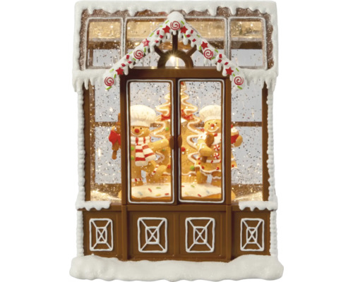 Decoratieve sneeuwbol in de vorm van een peperkoekhuis met peperkoekmannetjes