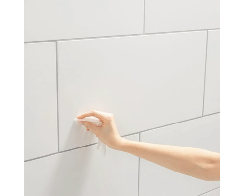 Reiniging van een betegelde wand met een reinigingsdoekje.