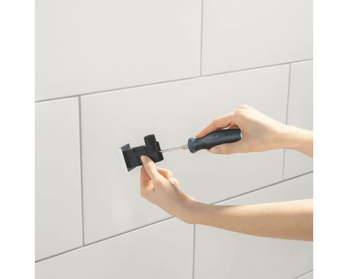 Installatie van een inbouwreservoir bedieningspaneel met schroevendraaier aan de wand