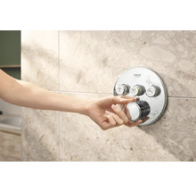 Hand bedient Grohe douchearmatuur op betegelde muur