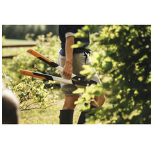 Een persoon houdt een hefboomtakkenzaag vast in een tuin