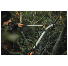 Een persoon gebruikt een takkenschaar om takken te snoeien.