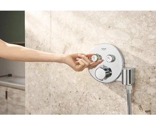 Vrouwenhand bedient Grohe douchearmatuur in de badkamer