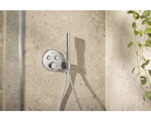 Douchearmatuur met handdouche op een betegelde muur