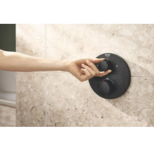 Hand bedient zwarte douchethermostaat van Grohe aan betegelde wand