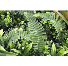 Kunstmatige plantenwand met varens en diverse groene bladeren.