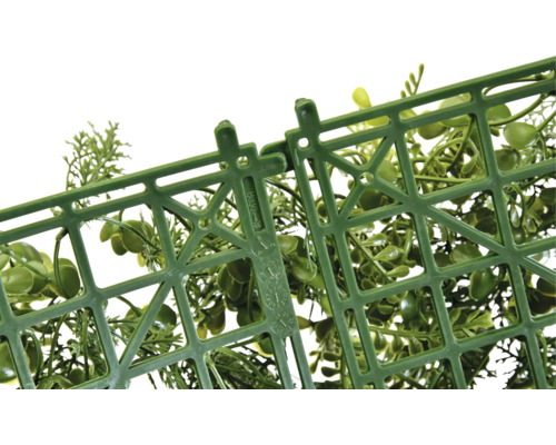 Gedetailleerde opname van een kunststof rooster met bevestigingsmechanisme en groene decoratieve planten.